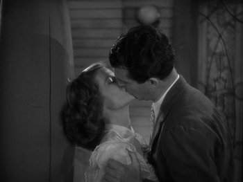 Movie still from “Alice Adams” (1935), directed by George Stevens – A black and white photo of a man and a woman kissing; Close Up shot, High angle