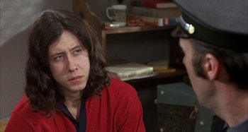 Movie still from “Alice's Restaurant” (1969), directed by Arthur Penn – A person sitting in a room talking to another person; Close Up shot, Over the shoulder angle