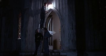 Movie still from “Alice's Restaurant” (1969), directed by Arthur Penn – Two men standing on a ladder outside of a building; Wide shot, Low angle