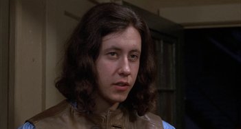 Movie still from “Alice's Restaurant” (1969), directed by Arthur Penn – A woman with long brown hair wearing a brown leather jacket; Close Up shot, Low angle