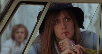 Movie still from “Alice's Restaurant” (1969), directed by Arthur Penn – A woman with a hat and a finger on her mouth; Close Up shot, Over the shoulder angle