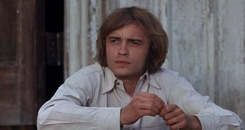 Movie still from “Alice's Restaurant” (1969), directed by Arthur Penn – A man with long brown hair wearing a white shirt; Close Up shot, Low angle