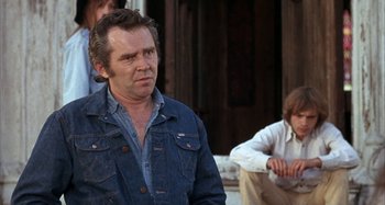 Movie still from “Alice's Restaurant” (1969), directed by Arthur Penn – A man wearing a jean jacket and jeans looks to his left; Medium shot, Over the shoulder angle