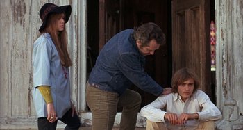 Movie still from “Alice's Restaurant” (1969), directed by Arthur Penn – A man and a woman standing next to a boy; Medium shot, Over the shoulder angle