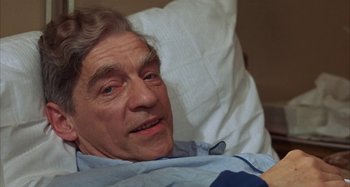 Movie still from “Alice's Restaurant” (1969), directed by Arthur Penn – An older man laying in a hospital bed; Close Up shot, High angle