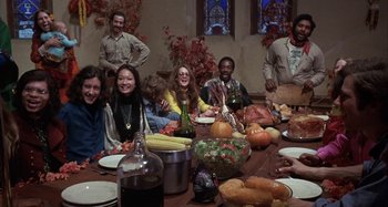 Movie still from “Alice's Restaurant” (1969), directed by Arthur Penn – A group of people sitting around a table with food; Wide shot, High angle