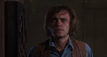 Movie still from “Alice's Restaurant” (1969), directed by Arthur Penn – A man with long brown hair wearing a brown vest; Close Up shot, Low angle