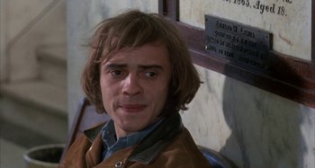 Movie still from “Alice's Restaurant” (1969), directed by Arthur Penn – A man with long brown hair wearing a brown jacket; Close Up shot, High angle