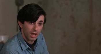 Movie still from “Alice's Restaurant” (1969), directed by Arthur Penn – A man with long black hair and a blue shirt; Close Up shot, Over the shoulder angle