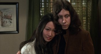 Movie still from “Alice's Restaurant” (1969), directed by Arthur Penn – A woman standing next to a man with long hair; Close Up shot, Low angle