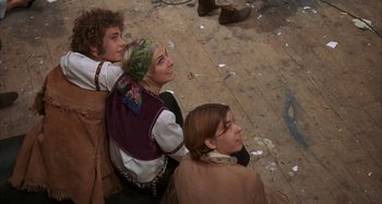 Movie still from “Alice's Restaurant” (1969), directed by Arthur Penn – A group of people sitting on the ground; Medium shot, Low angle