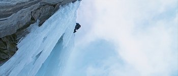 Movie still from “Alien vs. Predator” (2004), directed by Paul W.S. Anderson – A man is jumping over an icy waterfall; Extreme Wide shot, Low angle