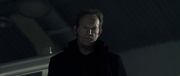 Movie still from “Alien vs. Predator” (2004), directed by Paul W.S. Anderson – A man in a black jacket is looking at the camera; Close Up shot, Low angle