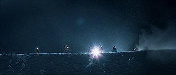 Movie still from “Alien vs. Predator” (2004), directed by Paul W.S. Anderson – A group of people standing on top of a snow covered slope; Extreme Wide shot, Low angle
