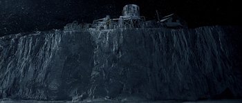 Movie still from “Alien vs. Predator” (2004), directed by Paul W.S. Anderson – A man standing on top of a cliff at night; Extreme Wide shot, High angle