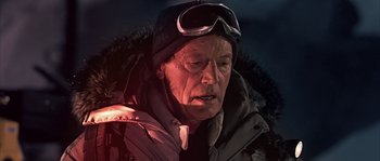 Movie still from “Alien vs. Predator” (2004), directed by Paul W.S. Anderson – An older man wearing a winter coat and a hat; Close Up shot, Over the shoulder angle