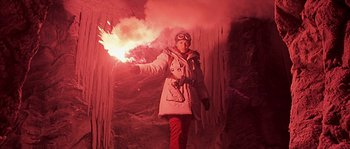 Movie still from “Alien vs. Predator” (2004), directed by Paul W.S. Anderson – A woman in a white jacket holding a fire; Medium shot, Low angle