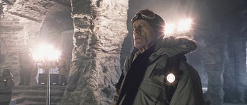 Movie still from “Alien vs. Predator” (2004), directed by Paul W.S. Anderson – An older man wearing goggles and a jacket; Medium shot, Low angle
