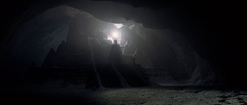 Movie still from “Alien vs. Predator” (2004), directed by Paul W.S. Anderson – A person is standing in a cave with a light shining on it; Extreme Wide shot, Low angle
