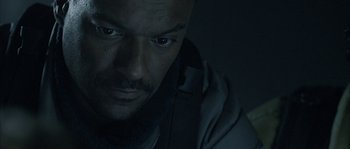 Movie still from “Alien vs. Predator” (2004), directed by Paul W.S. Anderson – A man's face in the dark; Close Up shot, Low angle