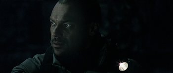 Movie still from “Alien vs. Predator” (2004), directed by Paul W.S. Anderson – A person with a flashlight in a dark room; Close Up shot, Low angle