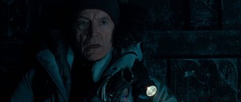 Movie still from “Alien vs. Predator” (2004), directed by Paul W.S. Anderson – An older man with a flashlight in a dark room; Close Up shot, Low angle