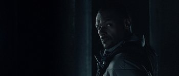 Movie still from “Alien vs. Predator” (2004), directed by Paul W.S. Anderson – A man in a dark room looking at the camera; Close Up shot, Low angle