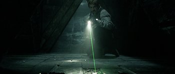 Movie still from “Alien vs. Predator” (2004), directed by Paul W.S. Anderson – A man is holding a flashlight and a green laser beam; Wide shot, High angle
