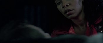 Movie still from “Alien vs. Predator” (2004), directed by Paul W.S. Anderson – A woman looking down at her cell phone in the dark; Close Up shot, Over the shoulder angle