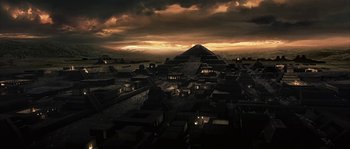 Movie still from “Alien vs. Predator” (2004), directed by Paul W.S. Anderson – An aerial view of a city at night with a pyramid in the background; Extreme Wide shot, High angle
