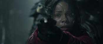 Movie still from “Alien vs. Predator” (2004), directed by Paul W.S. Anderson – A person holding a gun in a room; Close Up shot, Over the shoulder angle
