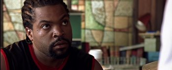 Movie still from “All About the Benjamins” (2002), directed by Kevin Bray – A person with a beard looking at the camera; Close Up shot, Over the shoulder angle