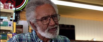 Movie still from “All About the Benjamins” (2002), directed by Kevin Bray – An older man wearing glasses and a plaid shirt; Close Up shot, Low angle