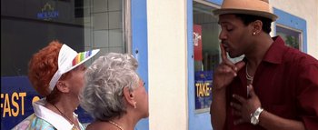 Movie still from “All About the Benjamins” (2002), directed by Kevin Bray – A woman and a man are talking outside a store; Close Up shot, Over the shoulder angle