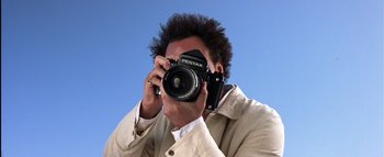 Movie still from “All About the Benjamins” (2002), directed by Kevin Bray – A man taking a picture with a pentax camera; Extreme Close Up shot, Overhead angle