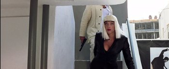 Movie still from “All About the Benjamins” (2002), directed by Kevin Bray – A woman in a white wig holding a gun while standing next to a man in a white suit; Medium shot, Low angle