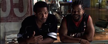 Movie still from “All About the Benjamins” (2002), directed by Kevin Bray – Two men sitting next to each other at a table; Close Up shot, Over the shoulder angle