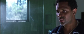 Movie still from “All About the Benjamins” (2002), directed by Kevin Bray – A man standing in front of a window in a room; Close Up shot, Low angle