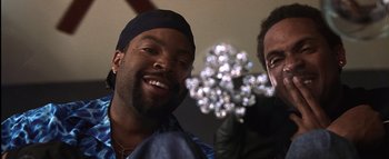 Movie still from “All About the Benjamins” (2002), directed by Kevin Bray – Two men smile for the camera while holding flowers; Close Up shot, Low angle