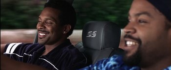 Movie still from “All About the Benjamins” (2002), directed by Kevin Bray – A man sitting in the back seat of a car; Close Up shot, Over the shoulder angle