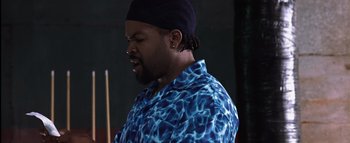 Movie still from “All About the Benjamins” (2002), directed by Kevin Bray – A man in a blue shirt and a black hat; Close Up shot, High angle