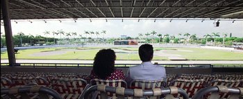 Movie still from “All About the Benjamins” (2002), directed by Kevin Bray – A man and a woman are sitting in a stadium; Extreme Wide shot, High angle