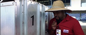 Movie still from “All About the Benjamins” (2002), directed by Kevin Bray – A man wearing a straw hat standing in front of a wall; Close Up shot, Overhead angle