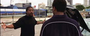 Movie still from “All About the Benjamins” (2002), directed by Kevin Bray – Two men are arguing in front of a fence; Medium shot, Over the shoulder angle