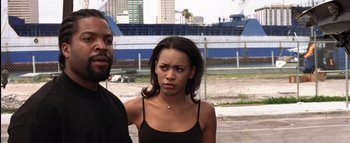 Movie still from “All About the Benjamins” (2002), directed by Kevin Bray – A woman standing next to a man in a parking lot; Close Up shot, Over the shoulder angle