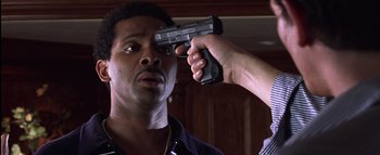 Movie still from “All About the Benjamins” (2002), directed by Kevin Bray – A man holding a gun up to his face; Close Up shot, High angle