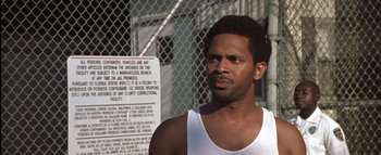 Movie still from “All About the Benjamins” (2002), directed by Kevin Bray – A man standing in front of a chain link fence; Close Up shot, Over the shoulder angle