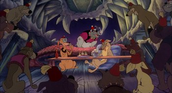 Movie still from “All Dogs Go to Heaven” (1989), directed by Dan Kuenster – A group of people sitting at a table with food; Wide shot, High angle