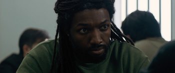 A person with dreads looking at the camera