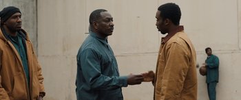 Two men standing next to each other holding hands